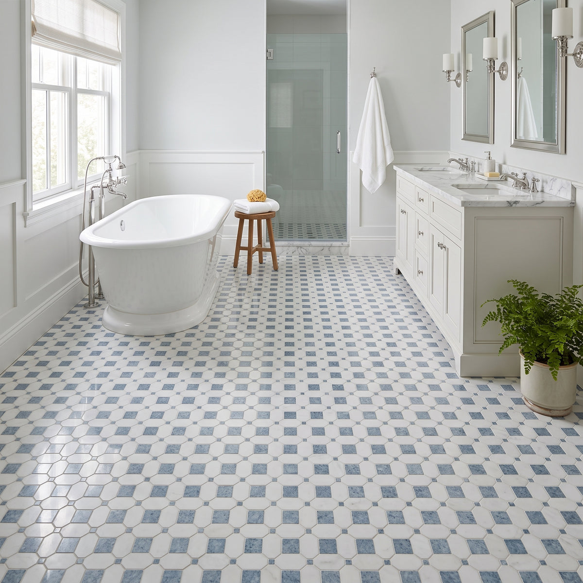 A bright, modern bathroom featuring a white freestanding clawfoot tub, a white double-sink vanity with mirrors, and a floor covered in white hexagonal tiles with a blue geometric diamond pattern.