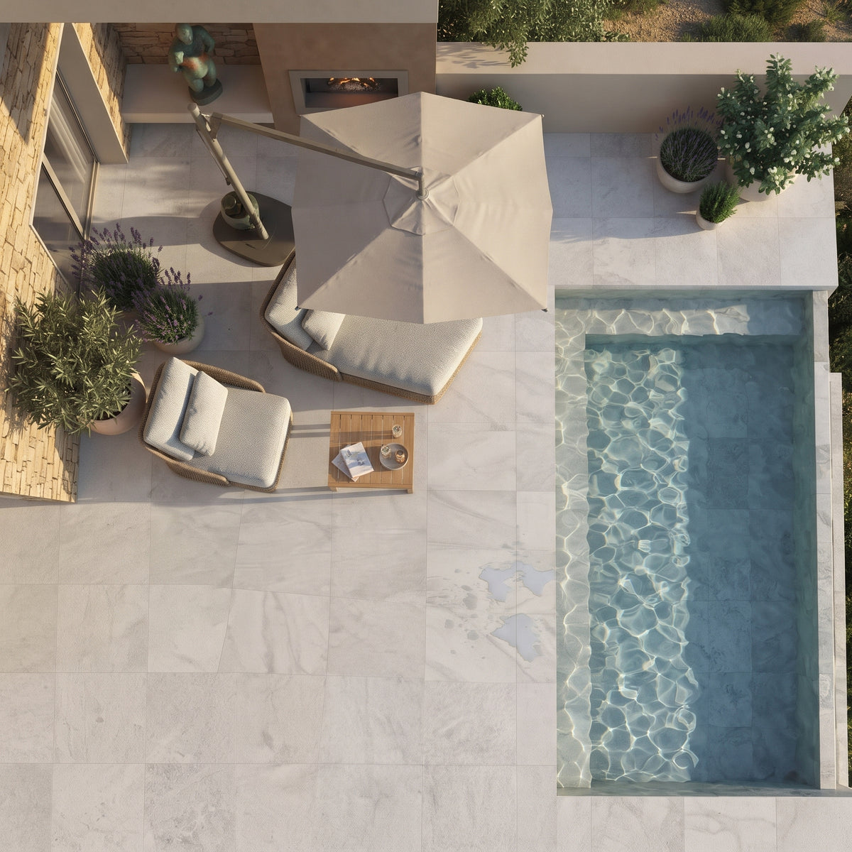 Overhead view of a luxury outdoor patio featuring light gray marble tiles, a rectangular swimming pool, a large beige patio umbrella, two wicker lounge chairs with white cushions, and potted green plants.