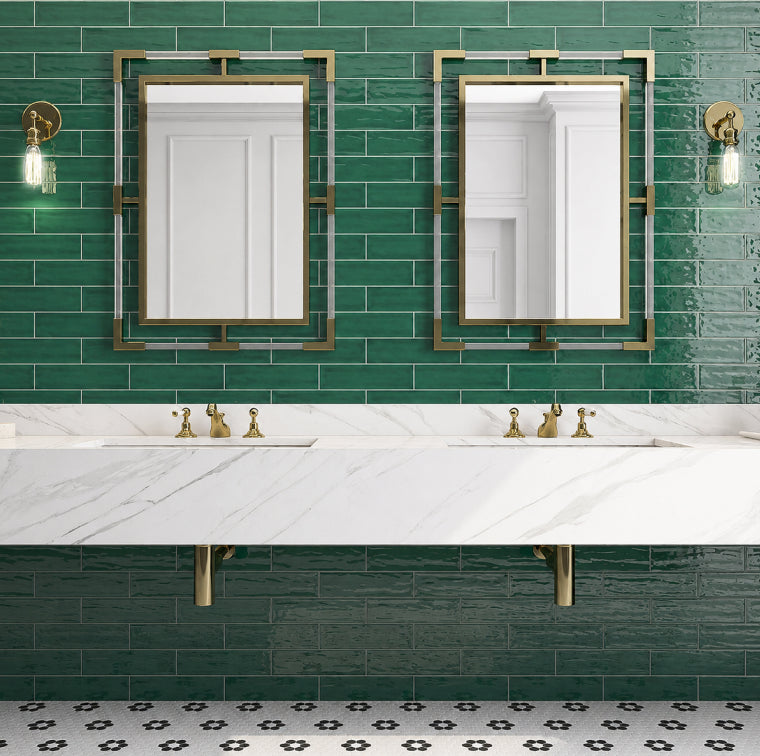 Green glossy subway tile bathroom with marble vanity and brass mirrors