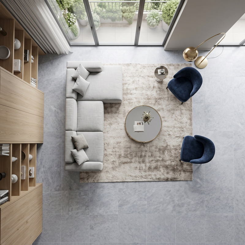 Modern living room featuring large-format Diamond Blue honed marble floor tiles in soft gray-blue tones with natural veining overhead view