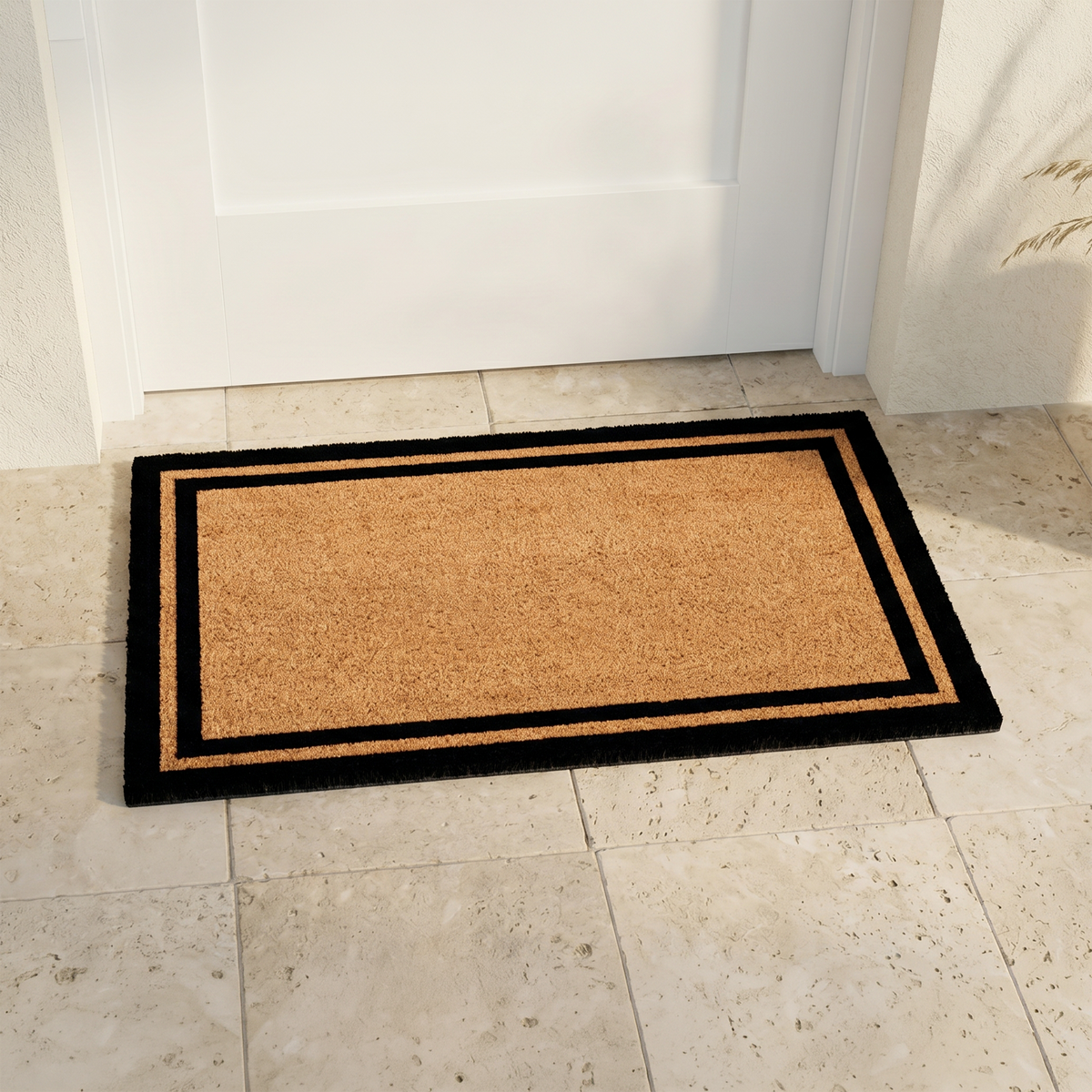 Double Black Border Coir Doormat, installed in a room