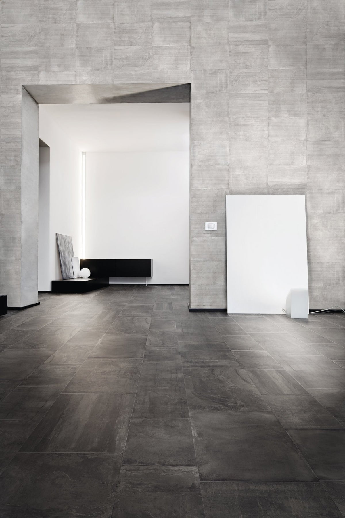 Ecocrete Weathered Black Honed Concrete Look Cove Base Porcelain Trim 6x12 installed in a living room