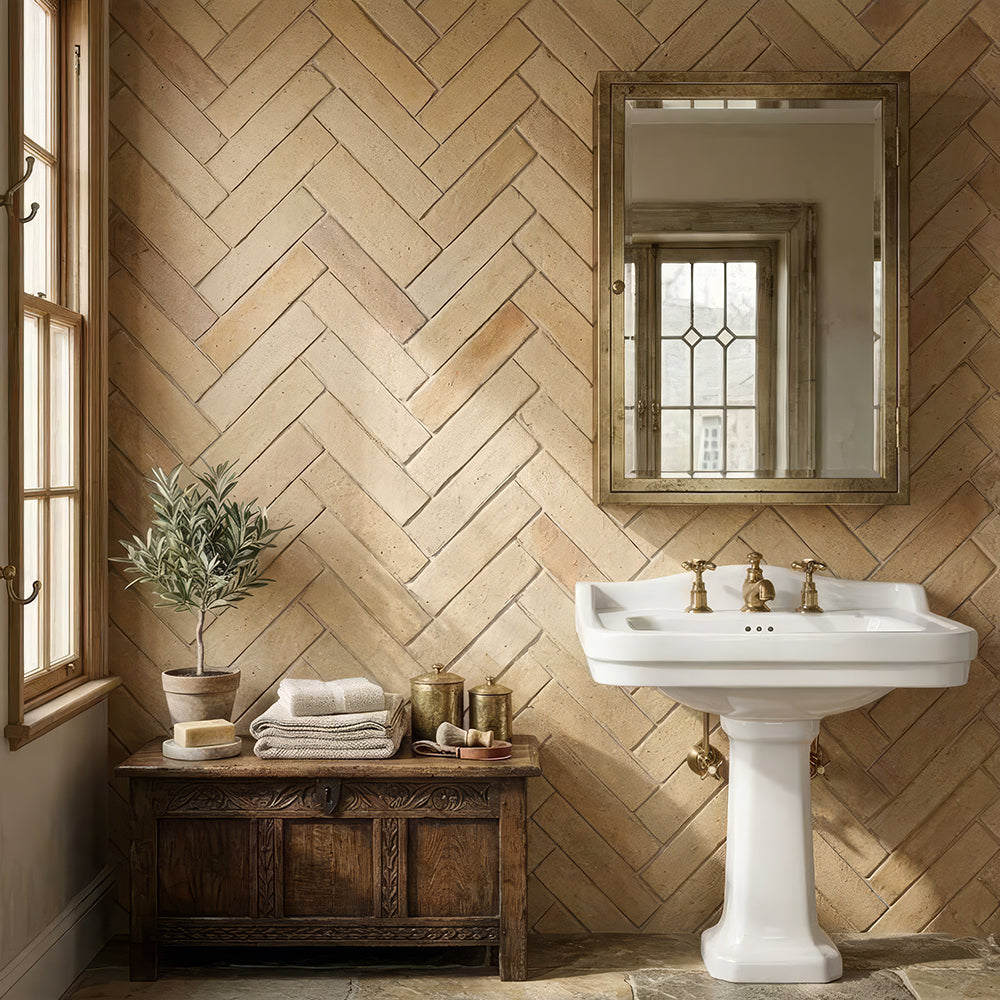 Bathroom with terracotta herringbone wall tile and a pedestal sink
